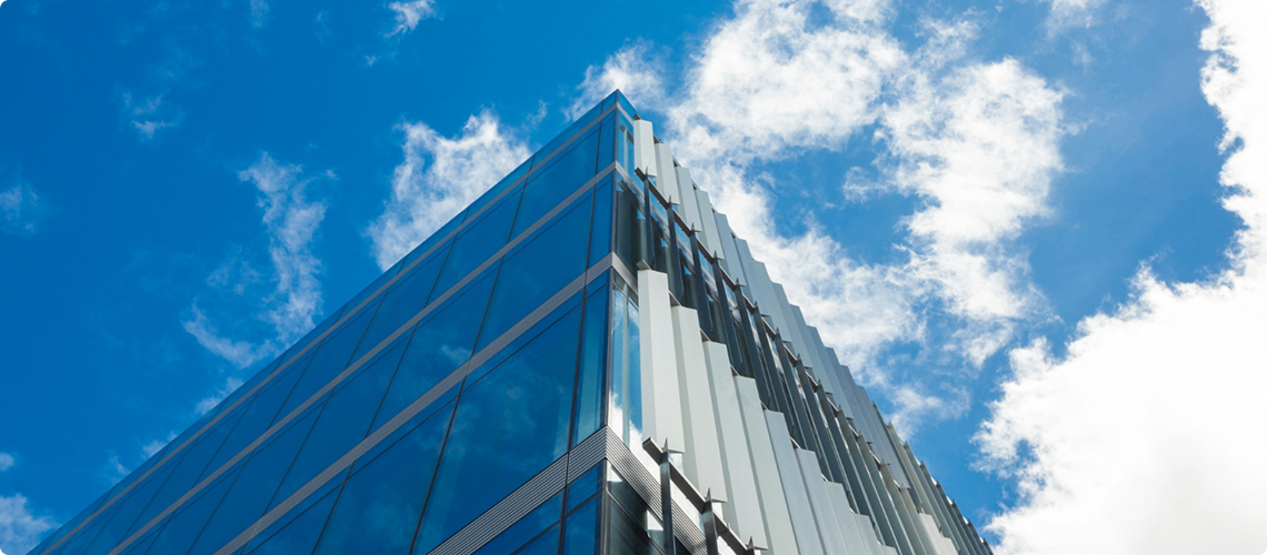 Glass office tower against a cloudy sky