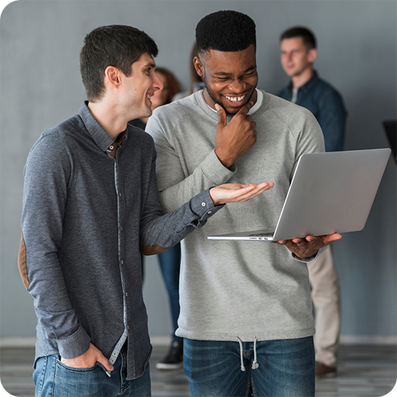Two colleagues reviewing work together on a laptop