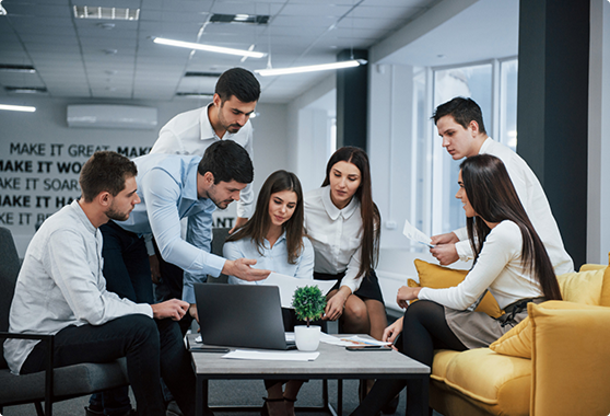 Team gathered around a laptop in a bright office